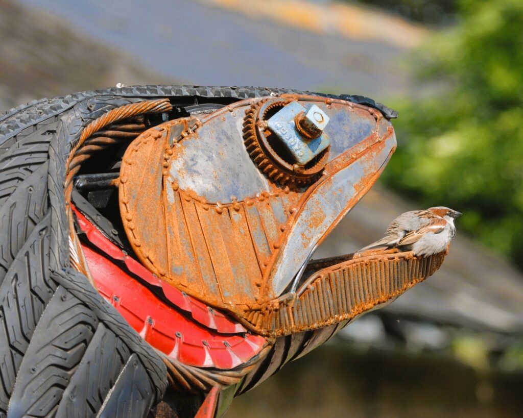 Fish sculpture with a sparrow resting in the mouth