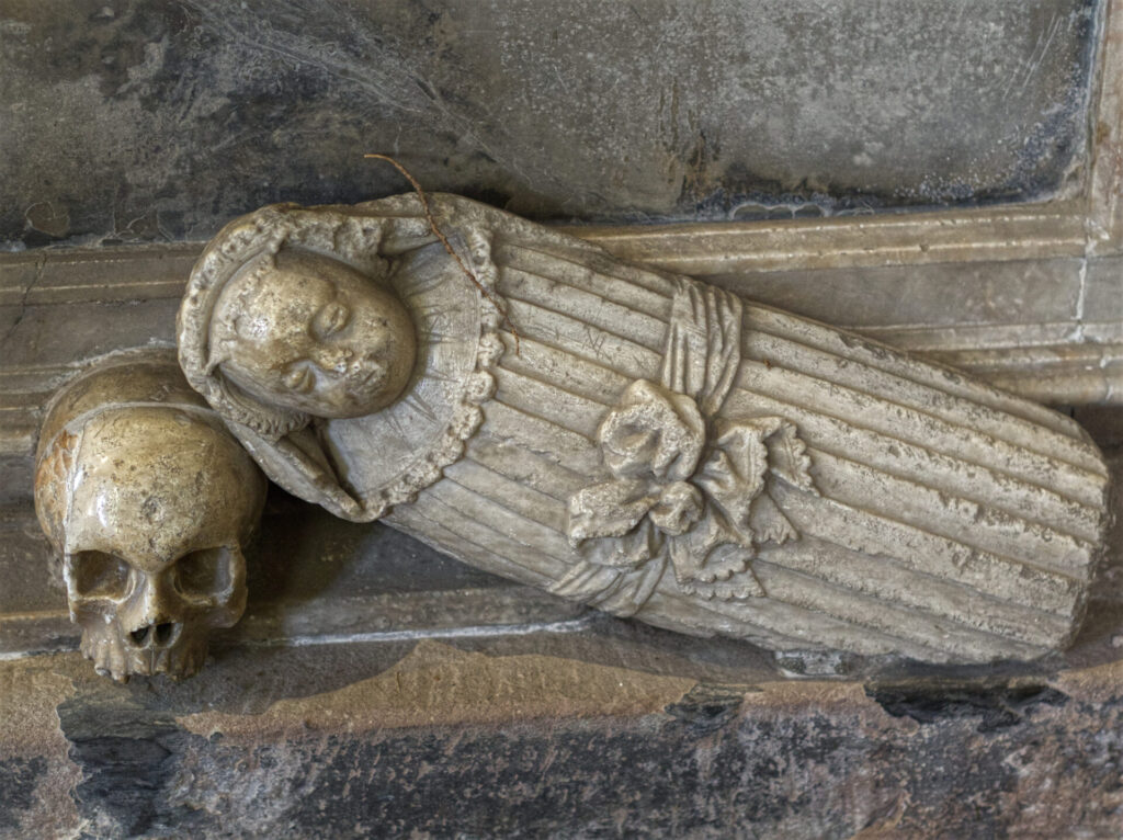 sculture detail of scull and baby wrapped in cloth